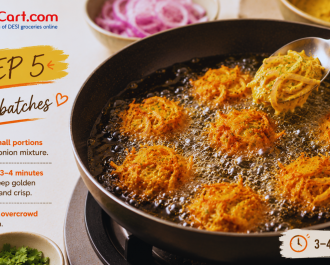 Fry the onion pakora in the hot oil until they turn crispy and golden brown.
